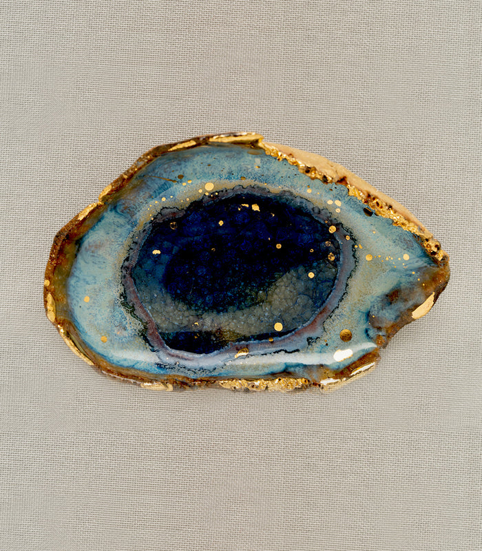 Azure Ring Dish by G-007, blue geode-style ring dish with gold-speckled edge on beige fabric.
