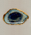 Azure Ring Dish by G-007, blue geode-style ring dish with gold-speckled edge on beige fabric.