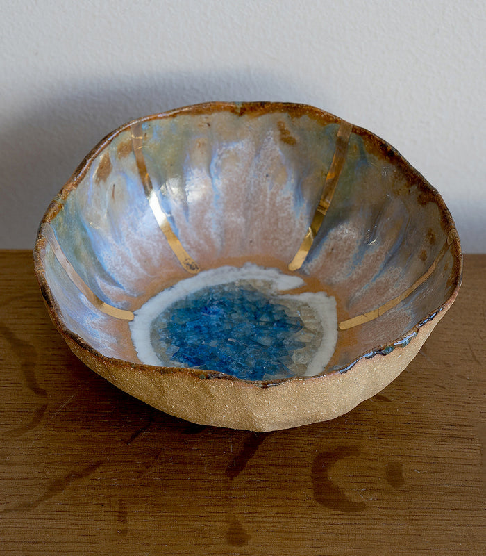 Blue Lagoon Ring Dish G-006 ring dish with blue ocean resin center and speckled gold rim on wood