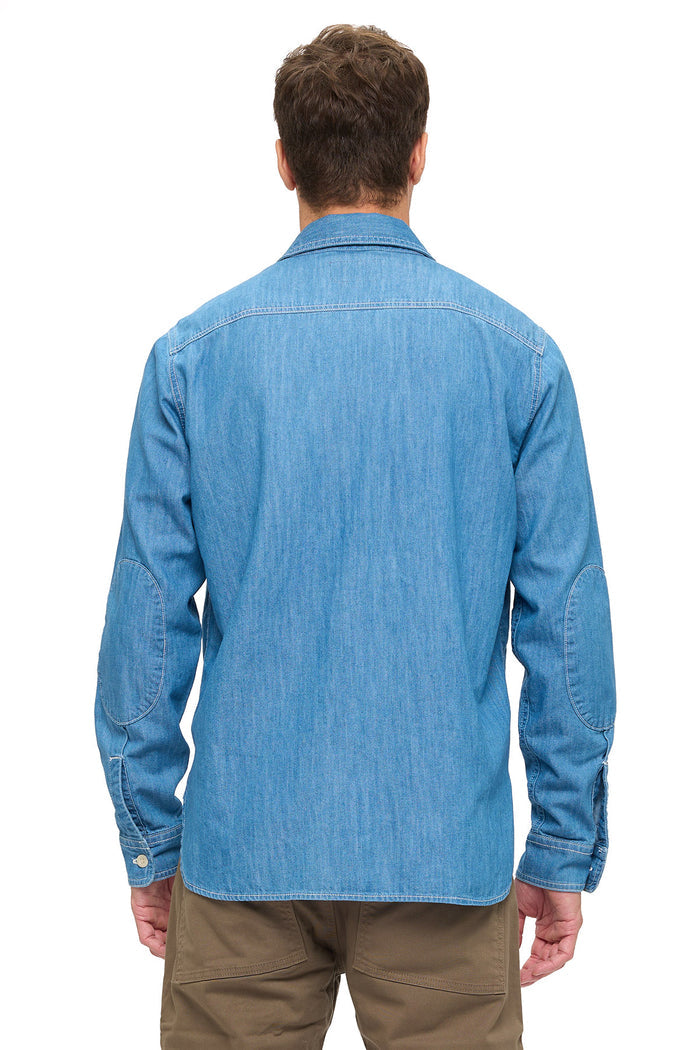 Man wearing a blue chambray shirt on a white background.