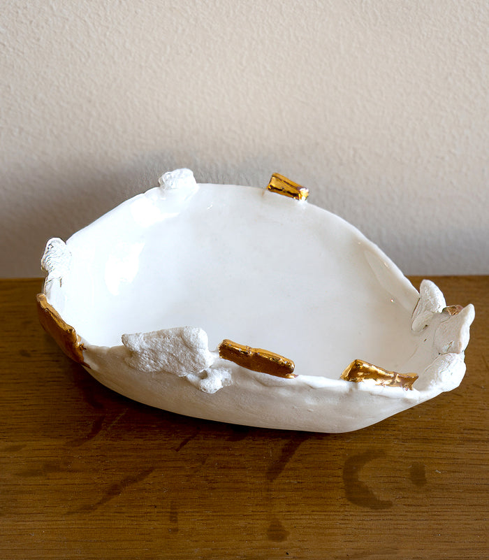Halo Ring Dish G-009 white ring dish with gold accents for holding rings on a wooden table