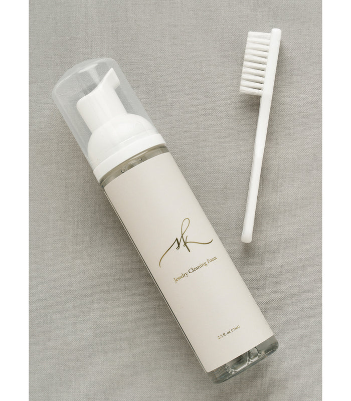Jewelry Cleaner by G-001-Lavish with white brush and foam bottle on beige fabric background